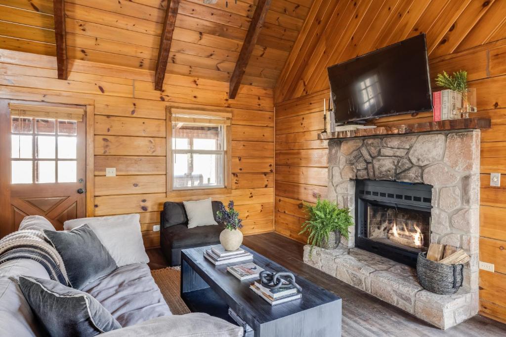 sala de estar con chimenea y TV en Dudley III by AvantStay Cosy Mountain Home w Hot Tub Great Views, en Pigeon Forge