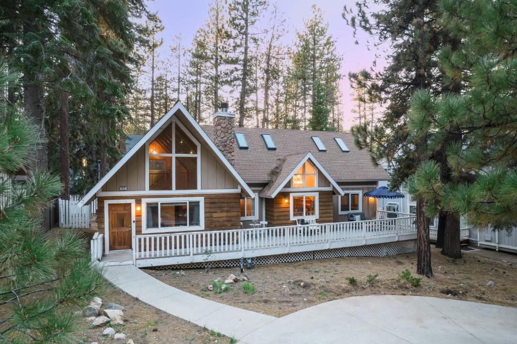 a log home with a white fence at Hartwood by AvantStay Cozy Big Bear Abode w Spacious Deck Stone Fireplace in Big Bear Lake