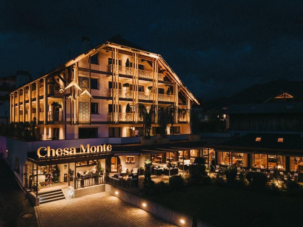 un edificio con un cartel que lee motivos chinos por la noche en Hotel Chesa Monte 4Sterne Superior, en Fiss