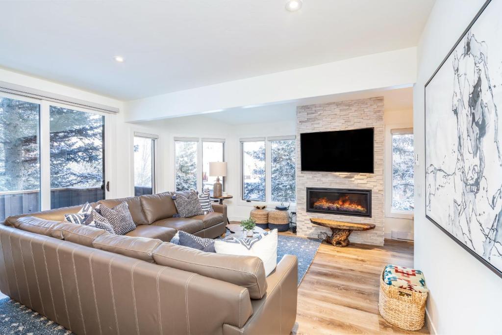 a living room with a couch and a fireplace at Manitou Riverhouse 115 by AvantStay Spacious Condo in the Centre of Telluride in Telluride
