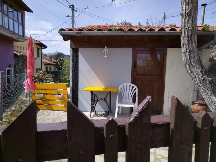 una pequeña casa con una mesa amarilla y una silla en La cabañina de zuce, en Parres de Llanes