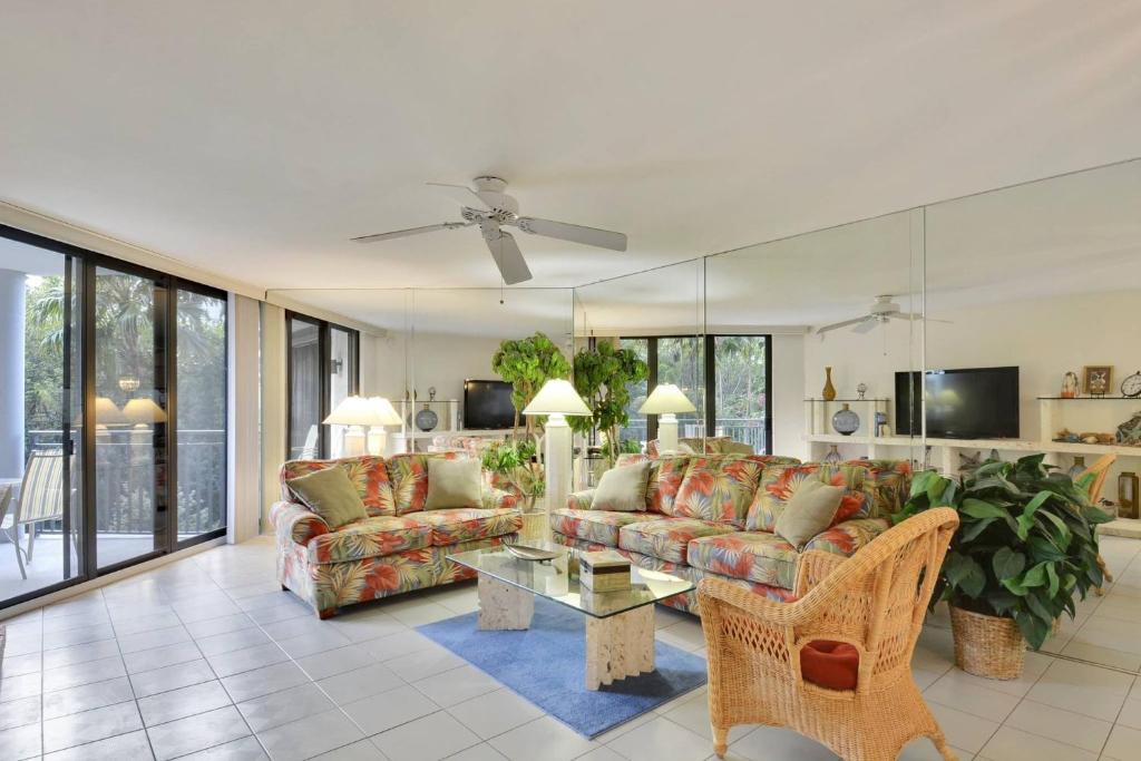 - un salon avec un canapé et une table dans l'établissement Atlantic Paradise by AvantStay Great Location w Balcony Outdoor Dining Shared Pool Hot Tub, à Key West