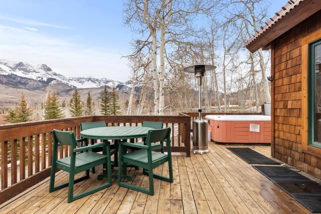 um pátio com uma mesa e cadeiras num deque em Russell Home by AvantStay Expansive Deck Stunning Views Hot Tub em Telluride