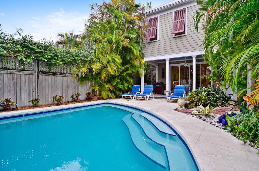 a swimming pool in front of a house at Amelia Home by AvantStay In Historic Old Town w Pool in Key West