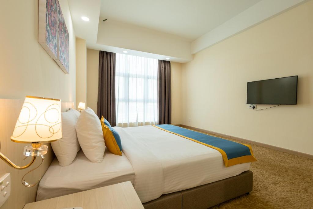 Zecon Hotel HPKK في كوالالمبور: غرفة فندقية بسرير كبير وتلفزيون بشاشة مسطحة