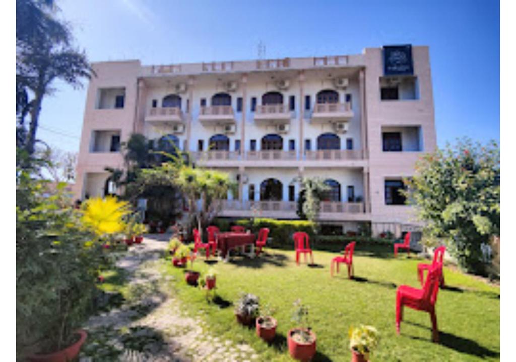 ein Gebäude mit roten Stühlen und Tischen davor in der Unterkunft Hotel Fort View Madhya Pradesh in Tīkamgarh