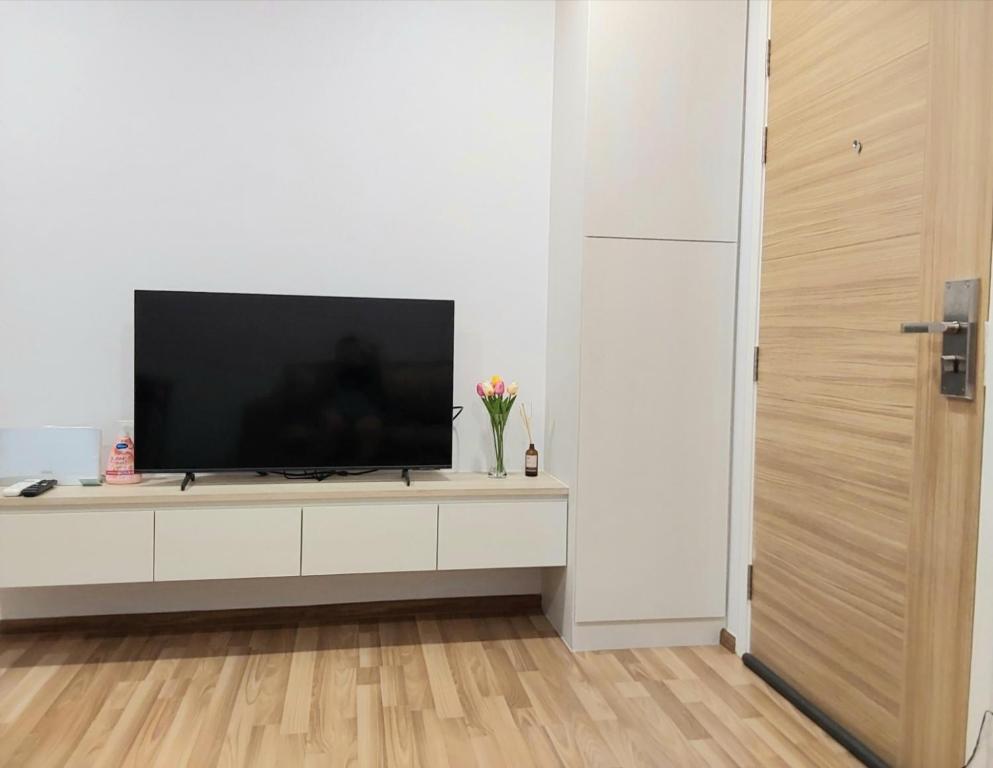 a living room with a television on a white cabinet at Sukhumvit​ 101 in Phra Khanong