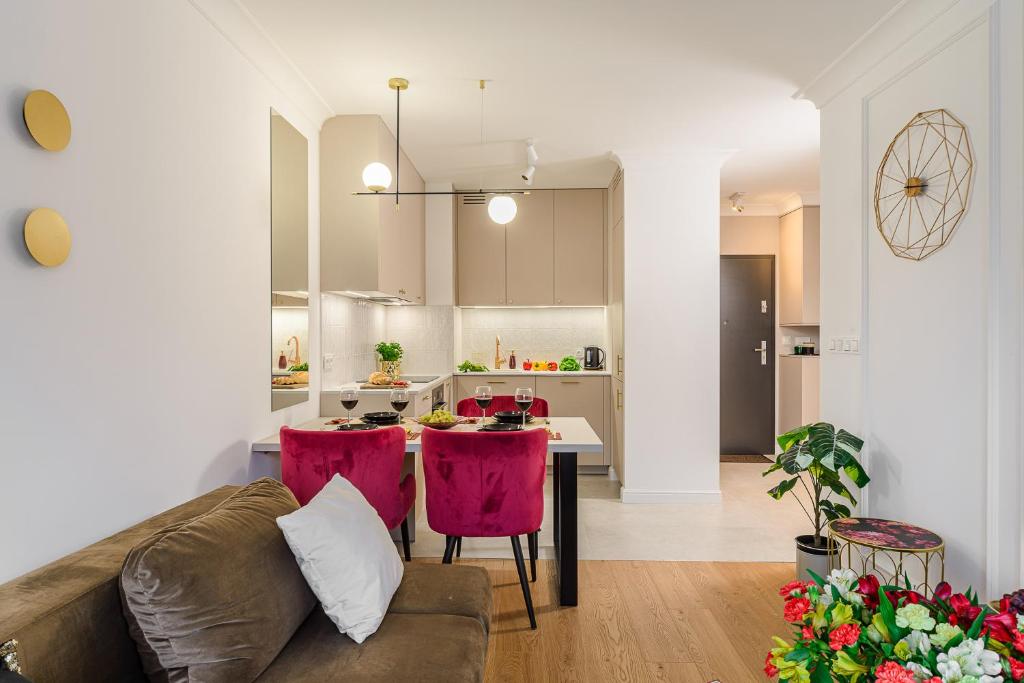 a living room with a couch and a table with pink chairs at Lumina I Premium Apartments with Balcony I Parking I Pasaż Łódzki in Łódź