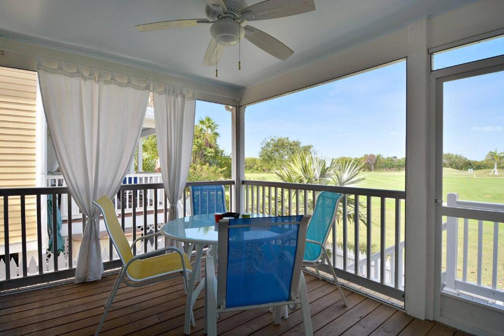 een afgeschermde veranda met een tafel en stoelen bij Coral Breeze by AvantStay Close to Beach w Balcony Shared Pool Month Long Stays Only in Stock Island