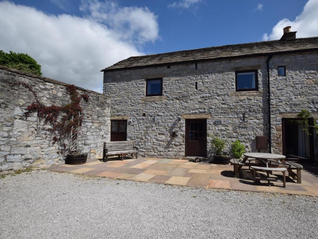 a stone building with a picnic table and benches at 3 Bed in Ashford in the Water PK501 in Great Longstone