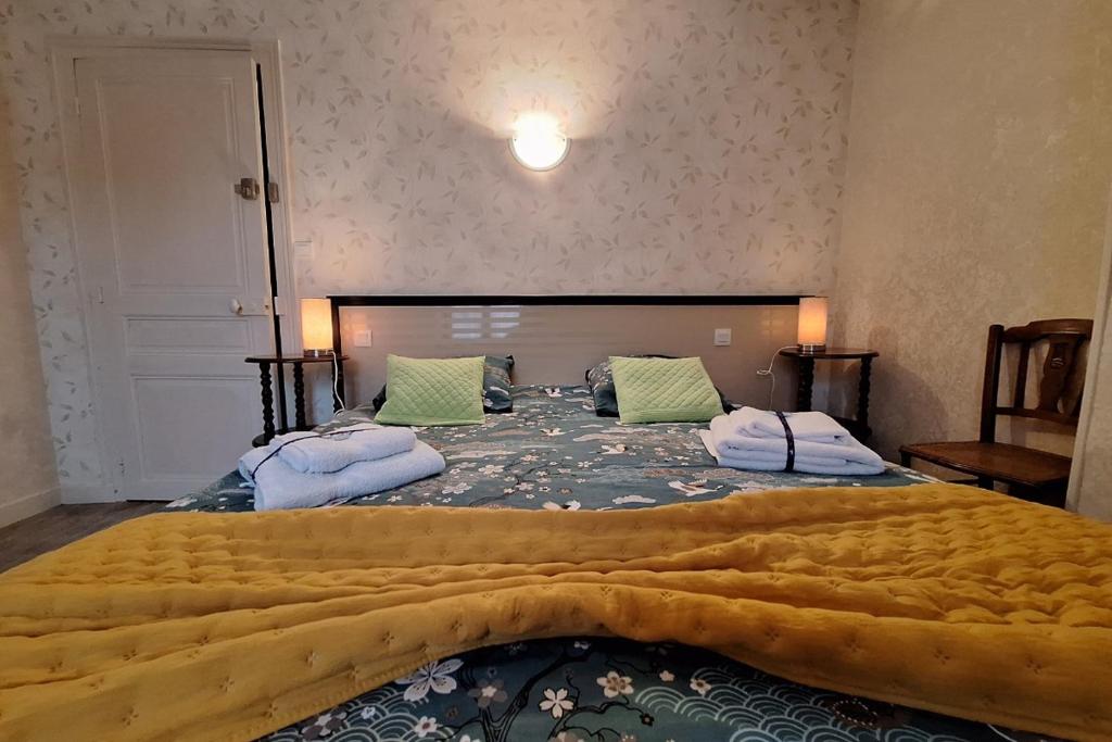 een slaapkamer met een groot bed en een gele deken bij Gîte Le Cep de Bouzy in Bouzy