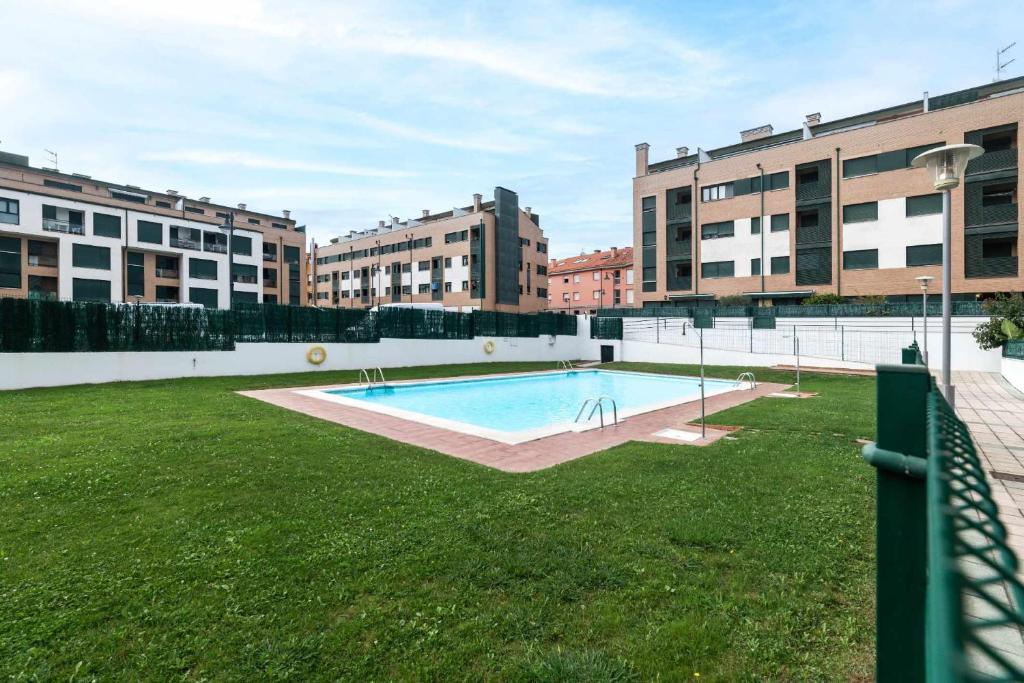 una piscina en medio de un patio con edificios en Apartamento Llanes Paraiso 206, en Posada de Llanes