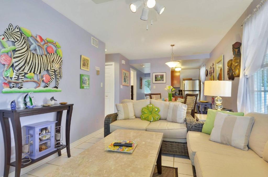 uma sala de estar com uma pintura de zebra na parede em Lavender Jungle by AvantStay Great Location w Patio Shared Pool Week Long Stays Only em Key West