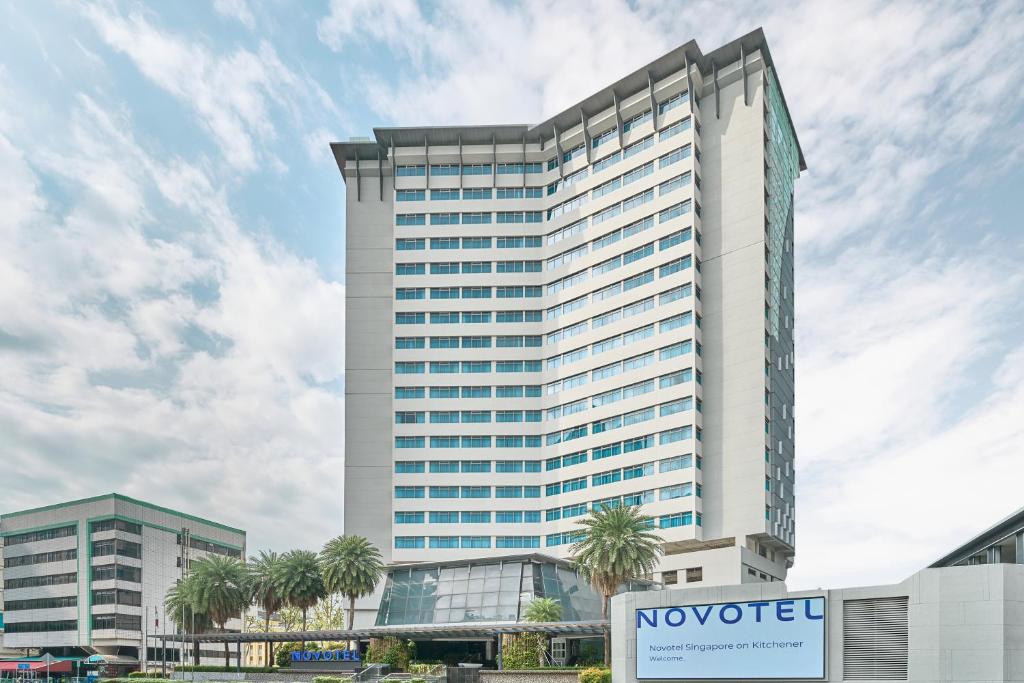 Novotel Singapore on Kitchener في سنغافورة: مبنى طويل مع علامة أمامه