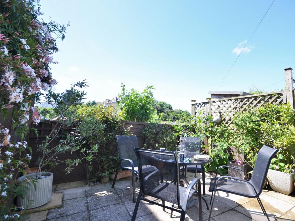 a patio with a table and chairs in a garden at 1 bed in Brixham BX046 in Brixham