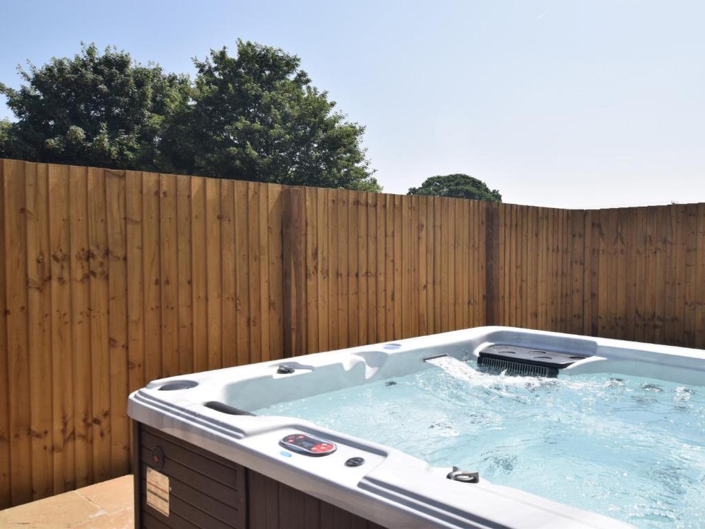 a hot tub in front of a wooden fence at 2 Bed in Croes-y-pant 58961 in Mamhilad