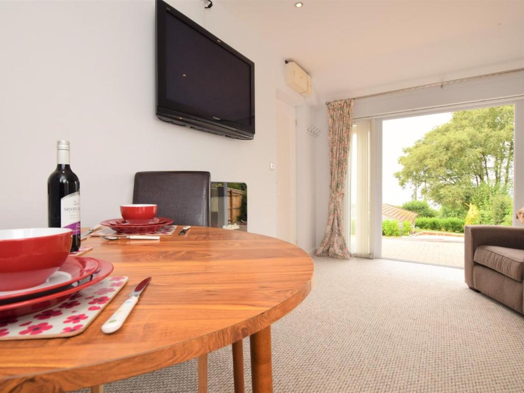 uma sala de estar com uma mesa de madeira e uma televisão em 1 Bed in Lyme Regis 62615 em Axminster