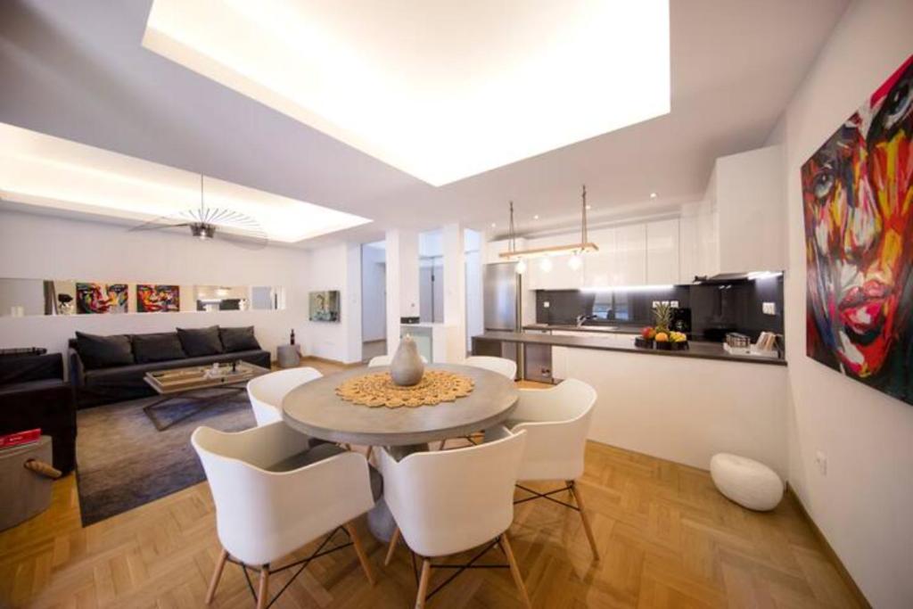 a kitchen and living room with a table and chairs at GLAMOROUS APARTMENT IN KOLONAKI CENTER in Athens