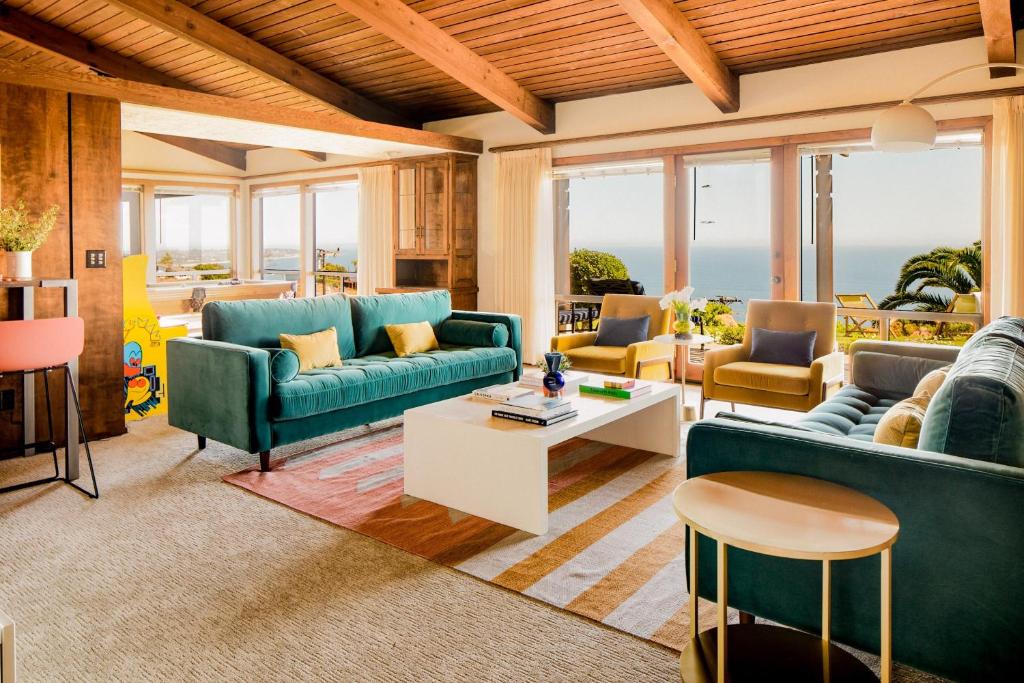 a living room with blue couches and a table at Cliffridge by AvantStay Lush Malibu Hills Estate w Breathtaking Ocean Views in Malibu