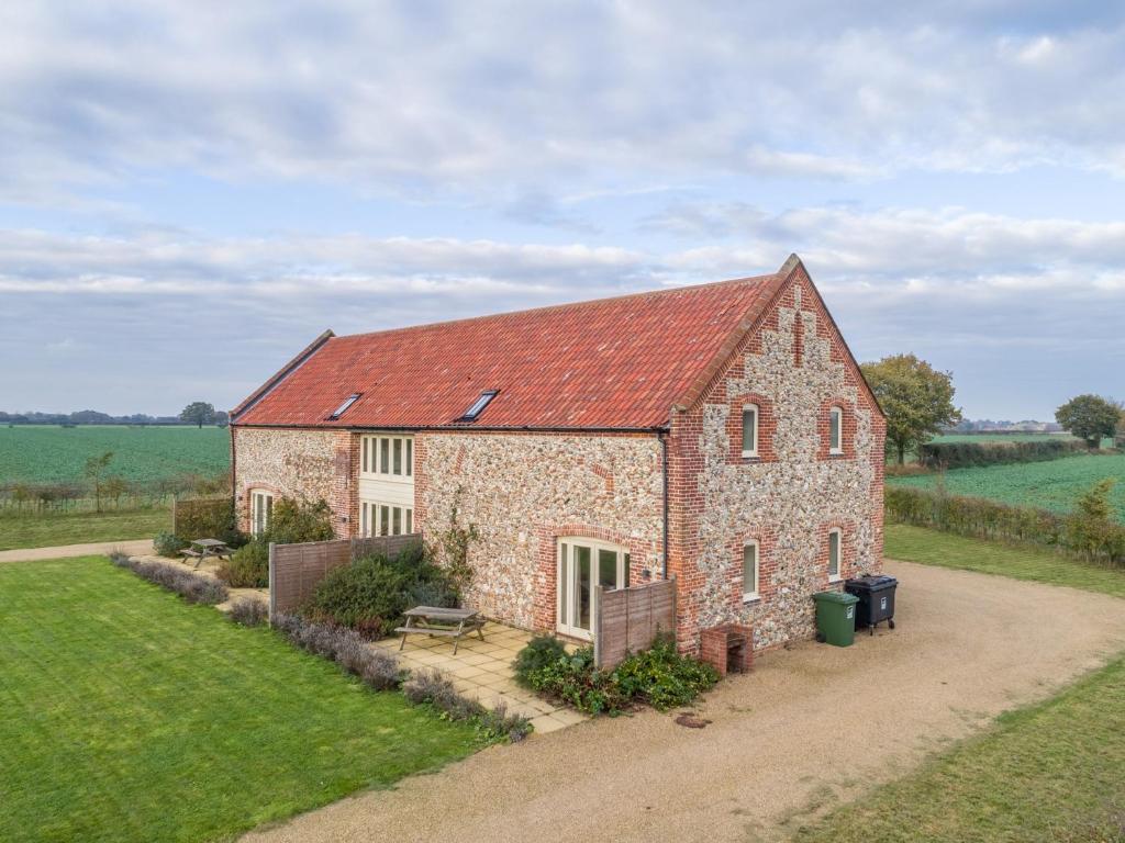 an old brick building with a red roof at 2 bed in Pensthorpe KT188 in Kettlestone