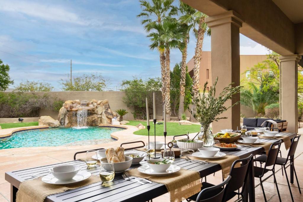 a table set for a meal next to a swimming pool at Arcadia by AvantStay Breathtaking Oasis in Scottsdale w Pool Hot Tub Game Room in Scottsdale