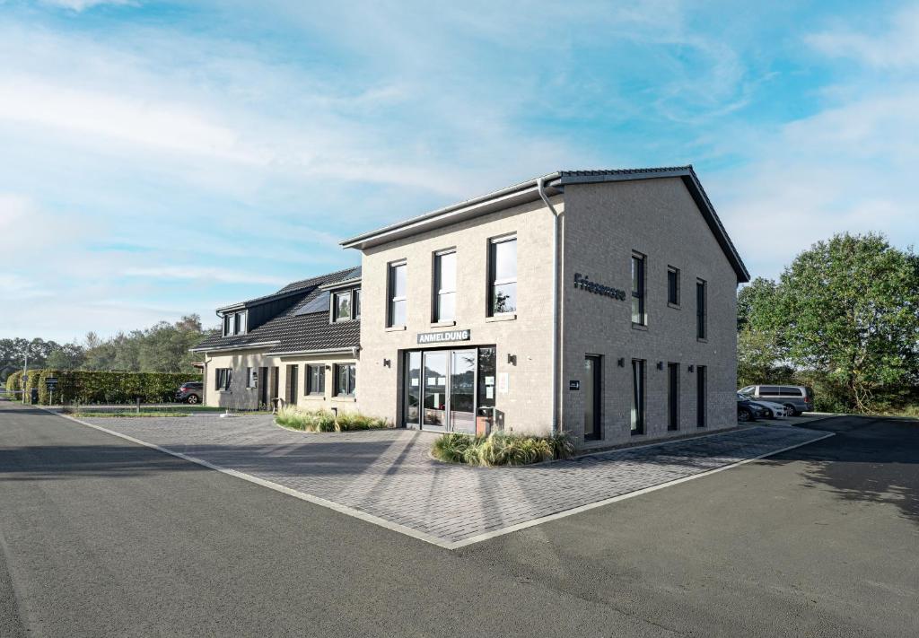 Un gran edificio blanco al costado de una calle. en Friesensee Camping und Ferienpark, en Wittmund