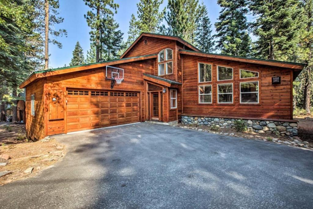 uma casa de madeira com uma garagem e um cesto de basquetebol em Moosetrack by AvantStay Cozy Cabin In The Of Tahoe Donner w Hot Tub em Truckee