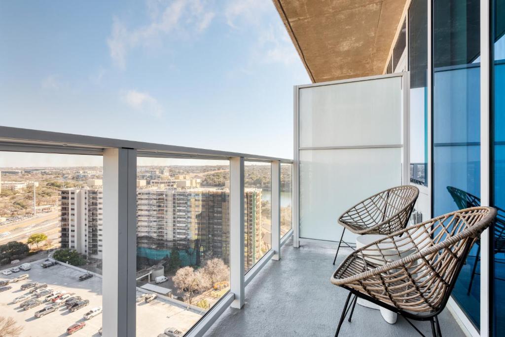 a balcony with two chairs and a view of a city at Vice by AvantStay Brand New Condo Room in Austin w Amazing Amenities in Austin