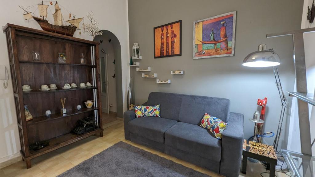 uma sala de estar com um sofá azul e uma prateleira em Il Cortile Siciliano Apartments em Trapani