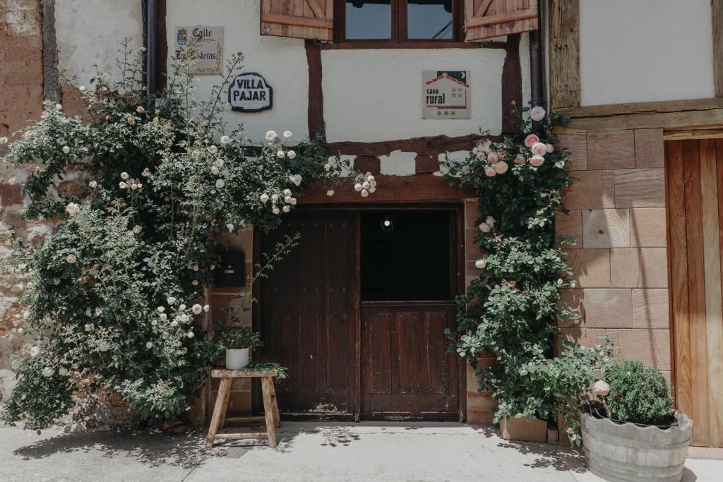 Una puerta a un edificio con flores. en Casa rural Villapajar, en Villasur de Herreros