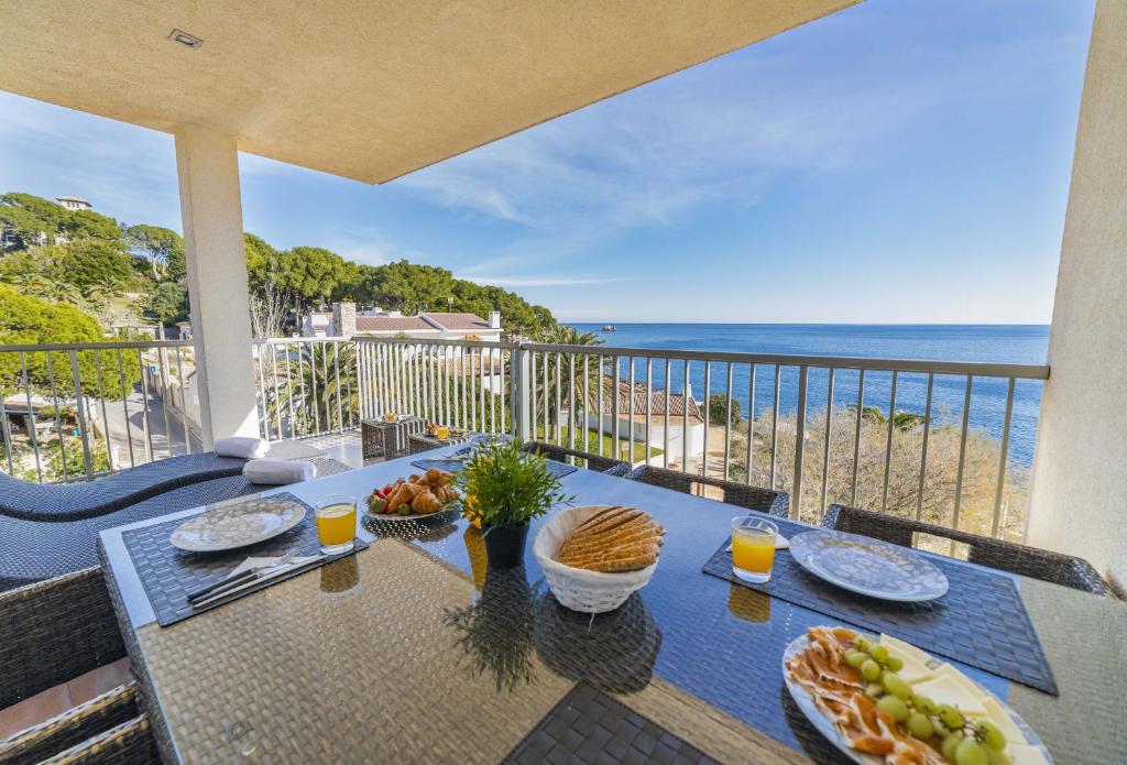 a table with food on top of a balcony with the ocean at Apartamento Bellavista Puerto 4B in Cala Ratjada