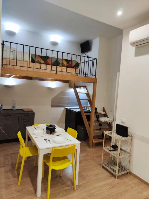 une chambre avec une table, des chaises et un lit mezzanine dans l'établissement La casa di Bibi, à Gênes