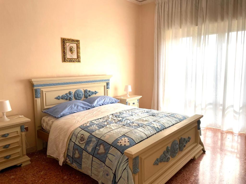 a bedroom with a bed with blue pillows and a window at La Casa Di Ida in Baiano