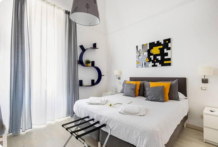 Casa dei nonni في Capurso: غرفة نوم بيضاء مع سرير كبير مع وسائد برتقالية