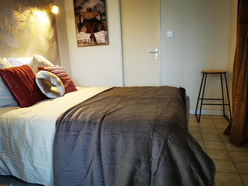 Un dormitorio con una cama con una manta. en L'appart d'Angélique, en Imling