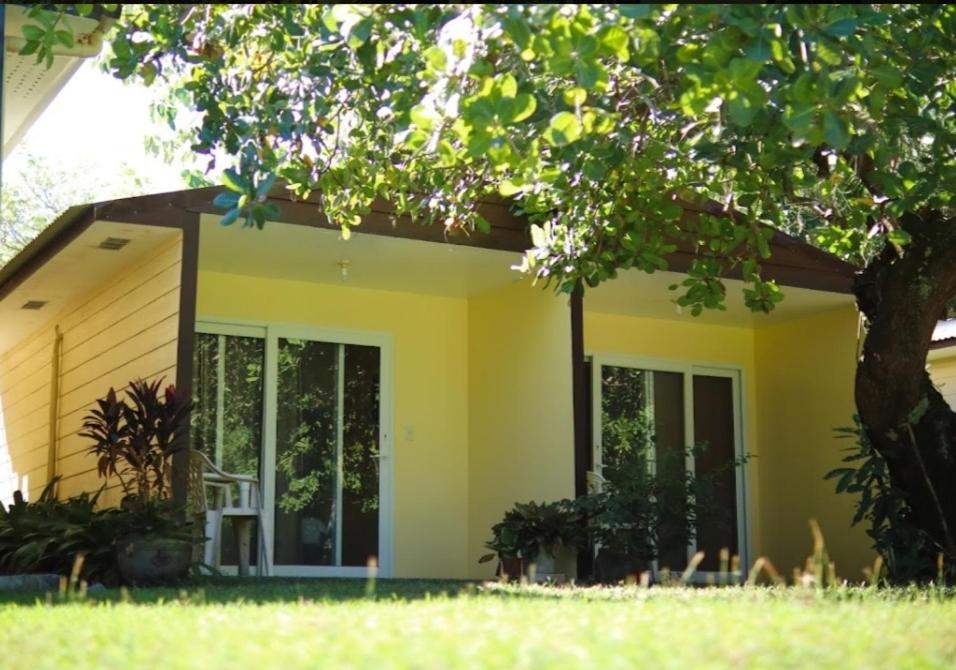 ein gelbes Haus mit einem Baum davor in der Unterkunft Hidaway Resort in Pundaquit