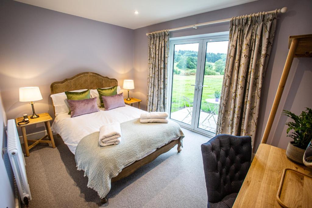 a bedroom with a bed and a large window at The Grange in Upper Arley