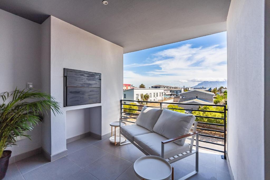 balcone con divano e vista sulla città di Chic Modern 2 bedroom beachfront with views, 6 Blue Tides a Bloubergstrand