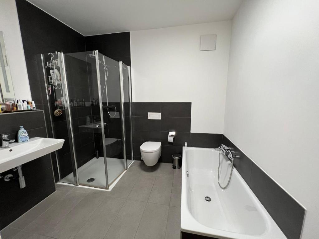 y baño con ducha, bañera y aseo. en Luxuriöse Loft Wohnung in Paderborn en Paderborn