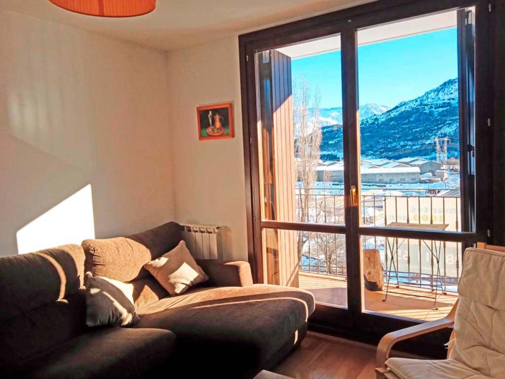 a living room with a couch and a large window at Apartamentos Sallent de Gállego 3000 in Sallent de Gállego