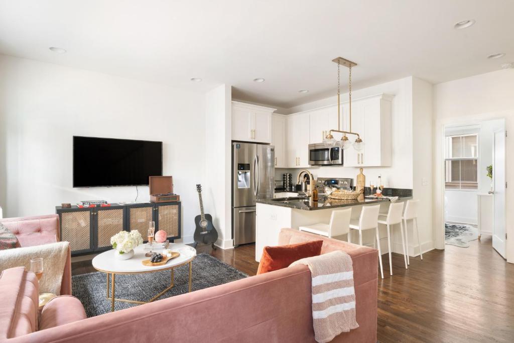 a living room with a couch and a table and a kitchen at Hart Suite 15 by AvantStay Gorgeous Town House w Modern Amenities in Nashville in Nashville