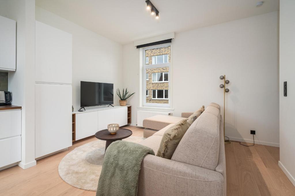 sala de estar con sofá y mesa en Verblijf in luxe in Gent design app in centrum 4p, en Gante