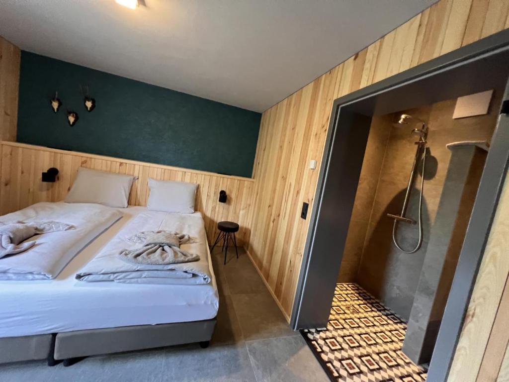 een slaapkamer met een groot bed en een douche bij Haus Bergquell App 4 in Willingen