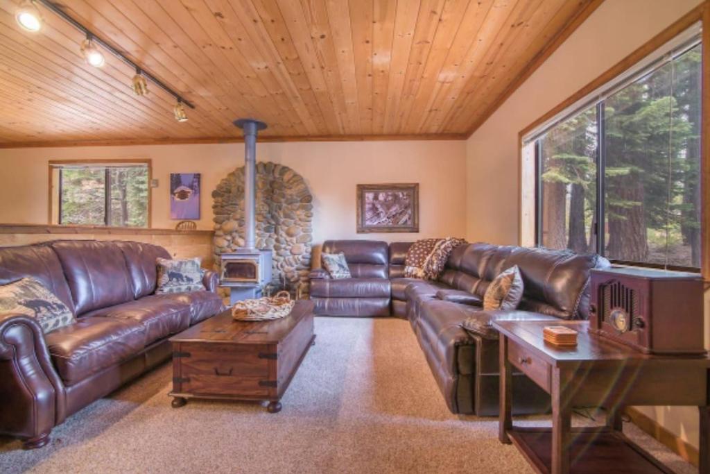 een woonkamer met een leren bank en een open haard bij Whiskey Springs by AvantStay Classic Cabin Near Tahoe Donner Ski Area in Truckee