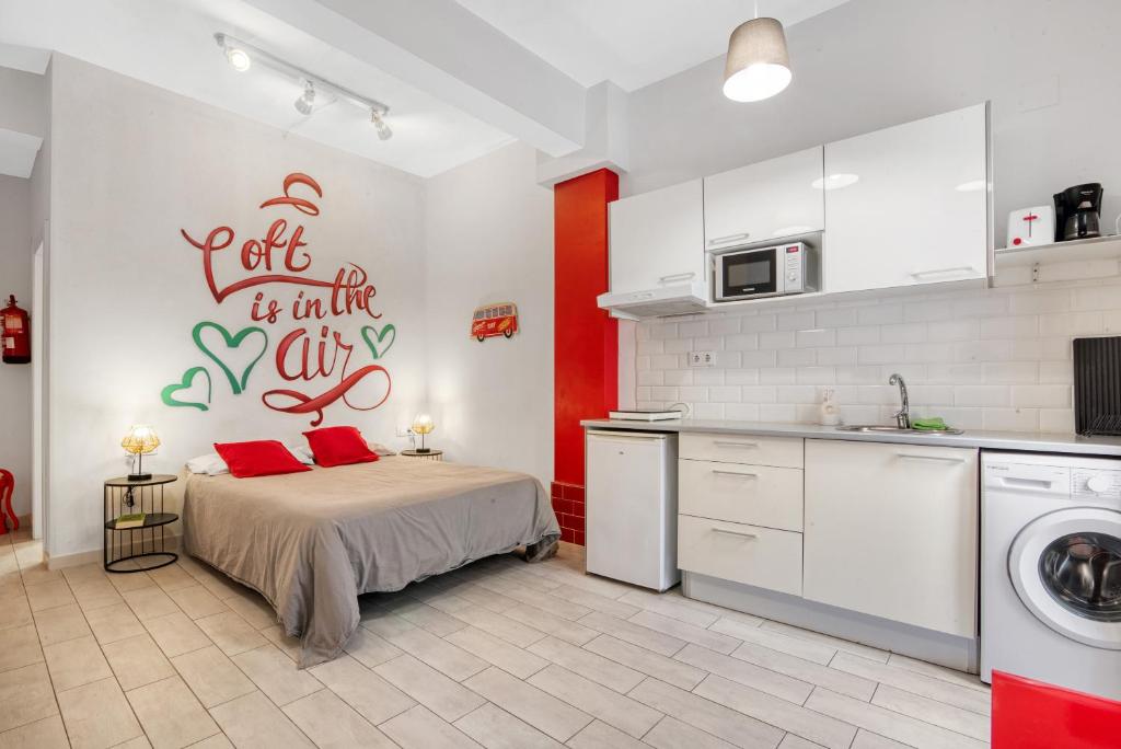 cocina con cama con almohadas rojas en una habitación en Loft Cabanyal en Valencia