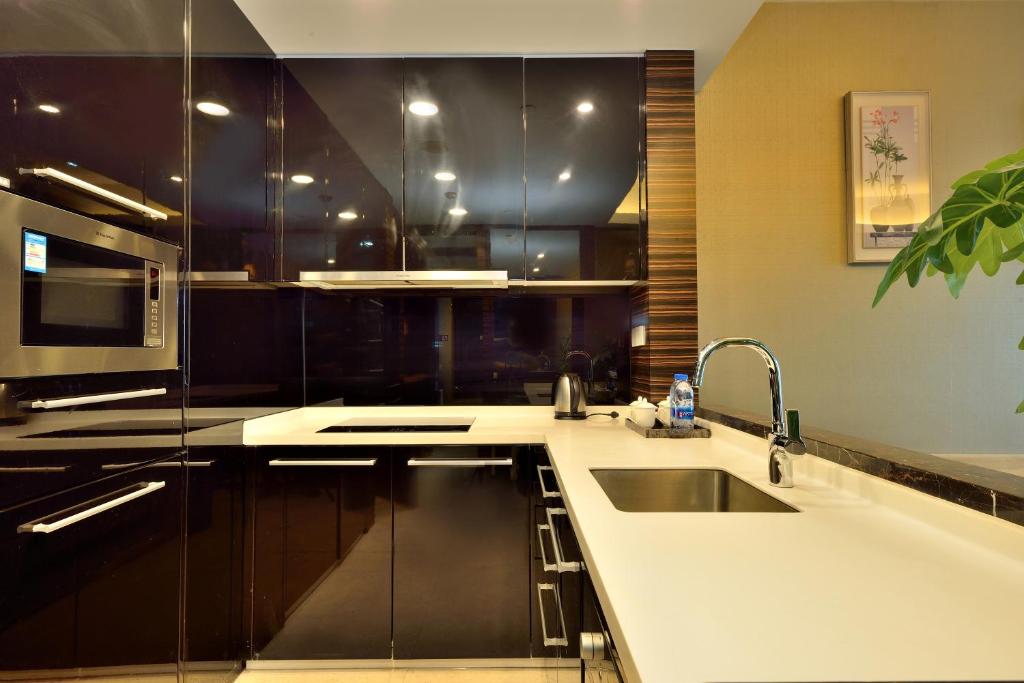 a kitchen with a sink and a microwave at HeeFun Apartment GZ -Poly World Trading Center-walking distance to Canton Fair in Guangzhou