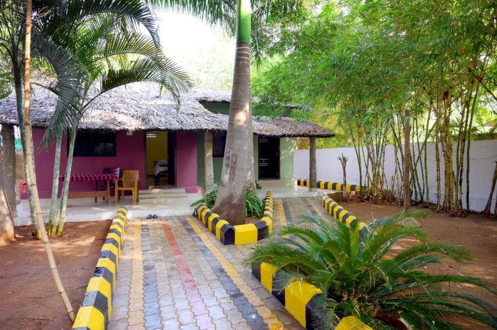 a resort with a palm tree and a building at Megha Resort , Hampi in Hampi