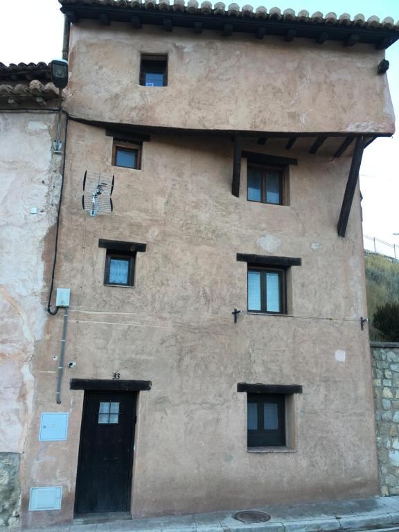 Un edificio con un montón de ventanas. en Casa San Antonio en Albarracín