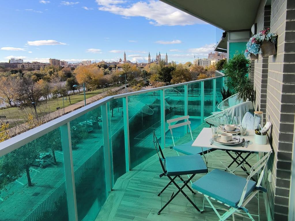 een balkon met een tafel en stoelen en uitzicht op de stad bij El Balcón del Ebro by Alogest- Vistas, piscina y con parking in Zaragoza