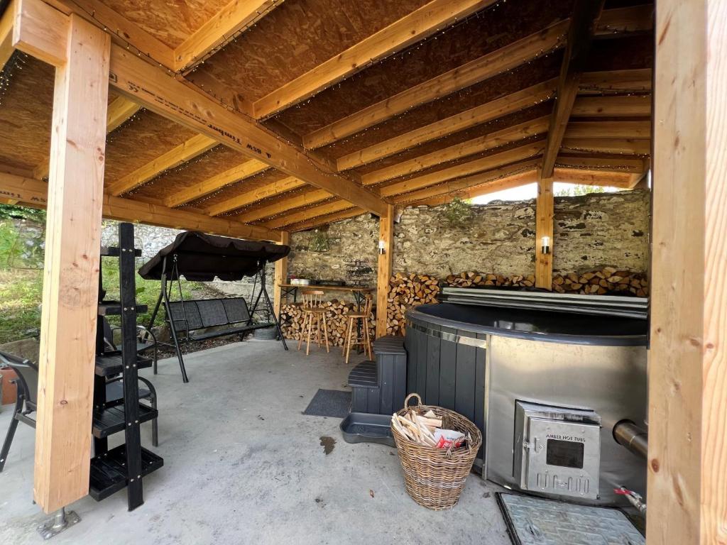 a patio with a wooden roof and a stove at 1 Bed in Pitlochry 75678 in Pitlochry